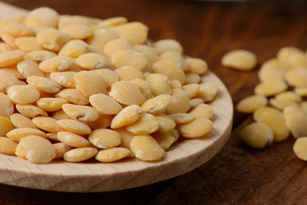 木製のスプーンで生の黄色のレンズ豆 — ストック写真