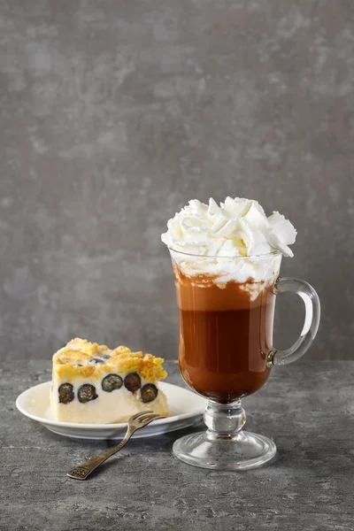 Кусок черничного чизкейка и стакан ирландского кофе — стоковое фото