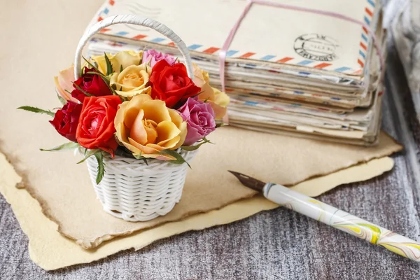 Cesta de rosas coloridas e letras vintage — Fotografia de Stock