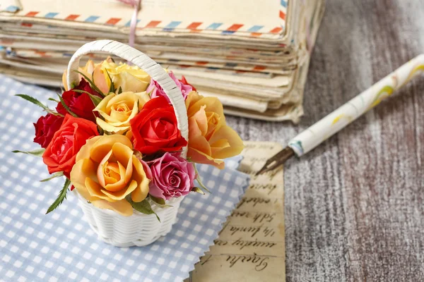 Basket of colorful roses and vintage letters — Stock Photo, Image