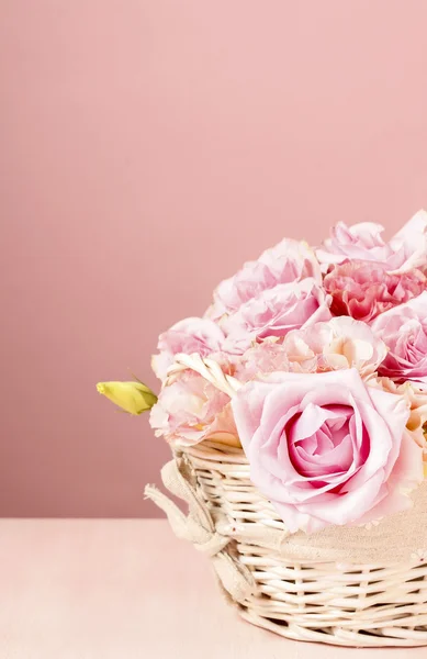 Розовые розы в белой плетеной корзине — стоковое фото