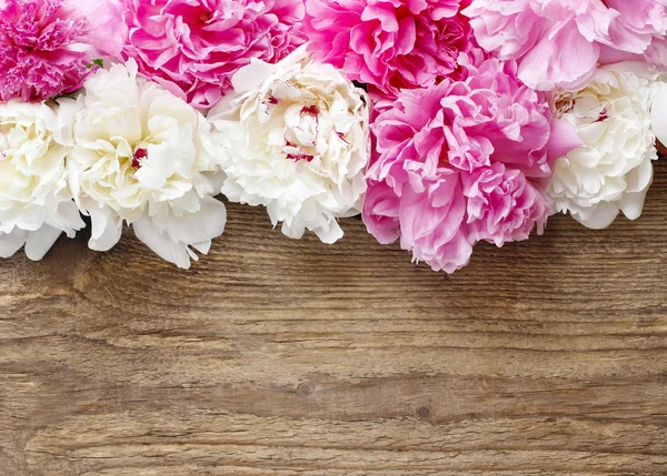 Atemberaubende rosa Pfingstrosen, gelbe Nelken und Rosen auf rustikalem — Stockfoto