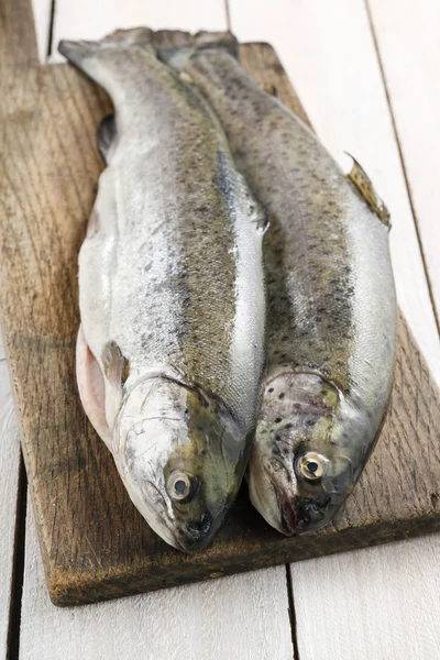 Two rainbow trouts on rustic wooden table — Stock Photo, Image