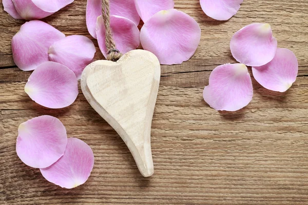 Corazón de madera y pétalos de rosa —  Fotos de Stock