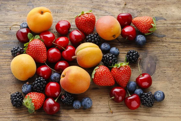 Deliciosas frutas no fundo de madeira . — Fotografia de Stock