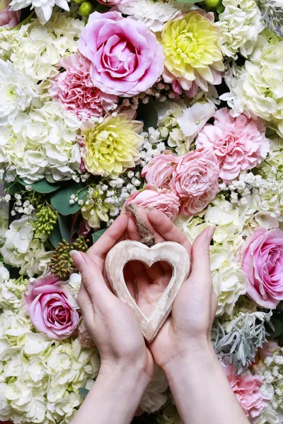 Mujer sosteniendo un corazón de madera. Adorno de flor romántica —  Fotos de Stock