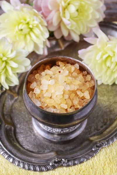 Bowl of yellow sea salt and dahlia flowers — Stock Photo, Image