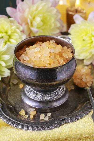 Bowl of yellow sea salt and dahlia flowers — Stock Photo, Image