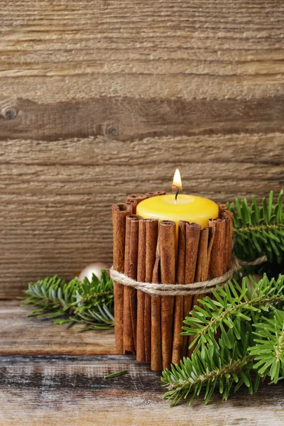 Candle decorated with cinnamon sticks — Stock Photo, Image