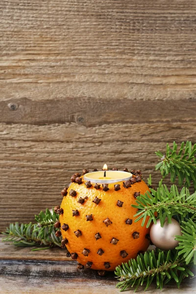 Orange pomander ball with candle on wooden table — Stock Photo, Image