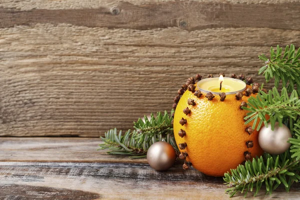 Orange pomander ball with candle on wooden table — Stock Photo, Image
