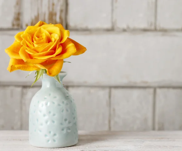 Single rose in ceramic vase on wooden background — Stok fotoğraf