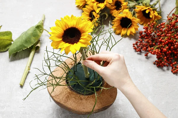 Флорист за работой: как сделать цветочную композицию с подсолнухами — стоковое фото