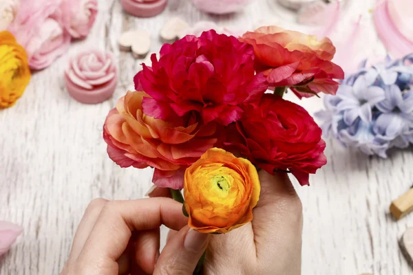 Květinářství v práci. Žena dělat kytice perské buttercup květi — Stock fotografie