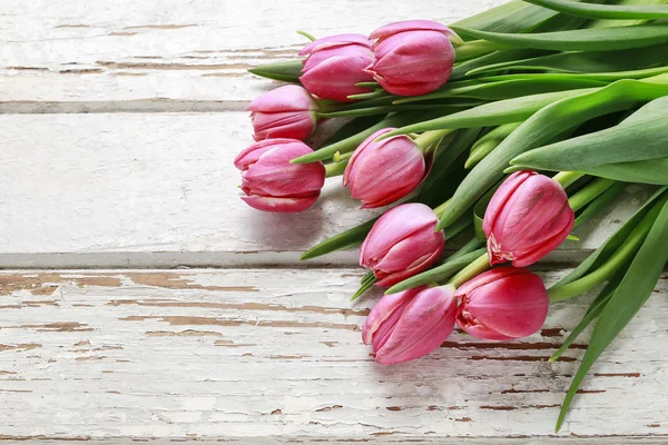 Belas tulipas rosa no fundo de madeira . — Fotografia de Stock