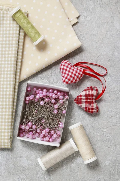 Juego de costura: telas, hilos y alfileres sobre fondo rosa —  Fotos de Stock