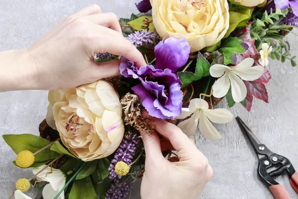 Mulher fazendo arranjo floral de mesa com flores artificiais — Fotografia de Stock