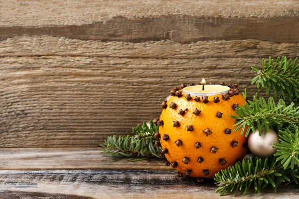 Orange pomander ball with candle on wooden table — Stock Photo, Image