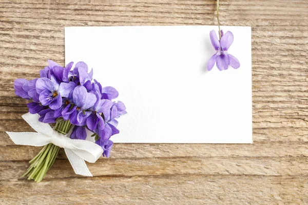 Boeket van violette bloemen (altviool odorata) en papier kaart — Stockfoto
