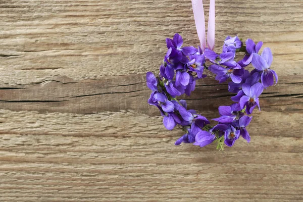 Small door wreath with tiny violets (viola odorata flowers) on w — Stock Photo, Image