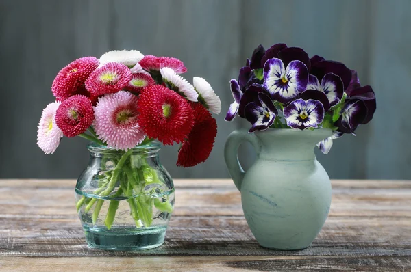 Bouquet of pansy flowers in ceramic vase and bouquet of red dais — Stock Photo, Image
