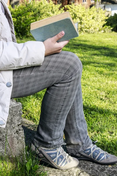Kobieta czytanie książki w ogrodzie — Zdjęcie stockowe