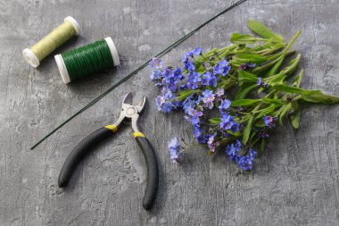 Çiçekçi iş başında: o unut-me-değil kapı çelenk yapma adımları