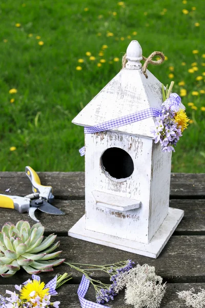 Casa de pájaros de madera y flores de primavera — Foto de Stock