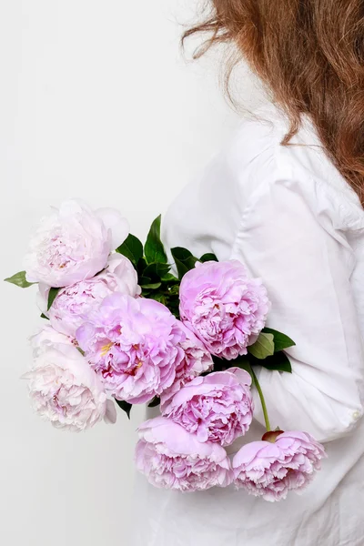 Donna con peonie rosa in mano — Foto Stock