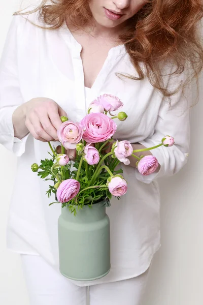 Woman holding vintage can with pink ranunculus — Stok fotoğraf