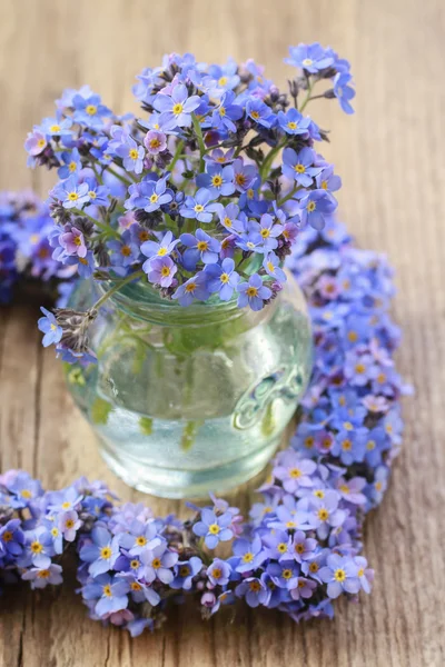 Bukiet niezapomnianych kwiatów w szklanym wazonie — Zdjęcie stockowe