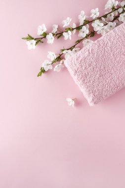 Pembe havlu ve pembe bir arka plan üzerinde çiçeklenme kiraz dallar
