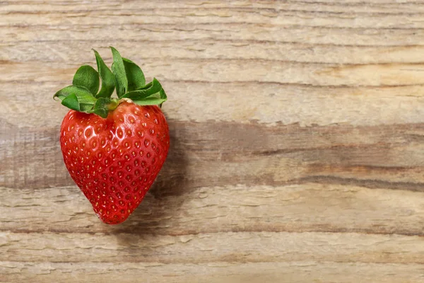 Single strawberry on wooden background — Stock Photo, Image