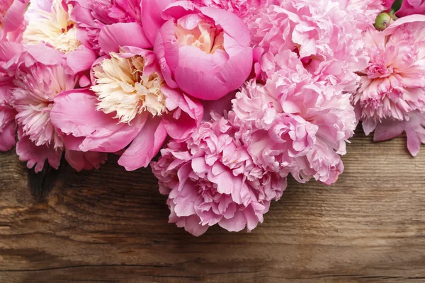 Impresionantes peonías rosadas sobre fondo de madera rústico marrón . —  Fotos de Stock