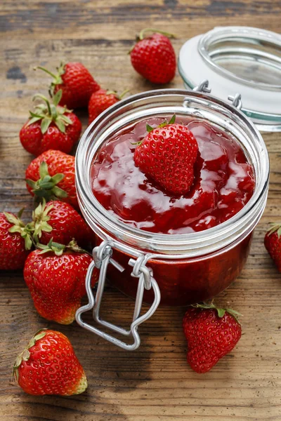 Jar of strawberry jam on wooden table — Stock Photo, Image