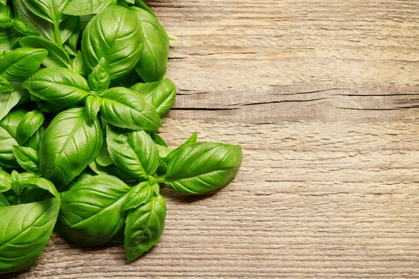 Hojas de albahaca sobre fondo de madera — Foto de Stock