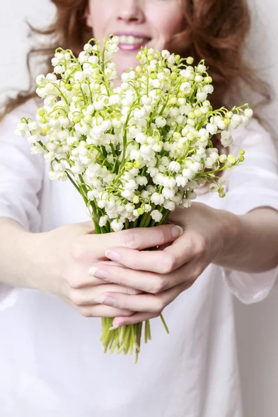 Woman holding bouquet of lily of the valley flowers — Stock Photo, Image