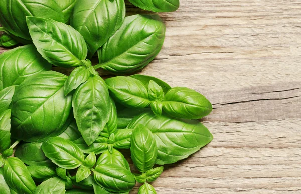 Hojas de albahaca sobre fondo de madera — Foto de Stock