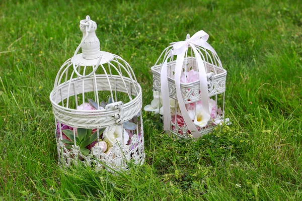 Decorazioni per feste in giardino. Gabbie per uccelli vintage con fiori all'interno — Foto Stock