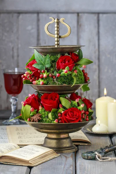 Цветочные украшения с красными розами, омелой и мхом. Шаг за шагом — стоковое фото