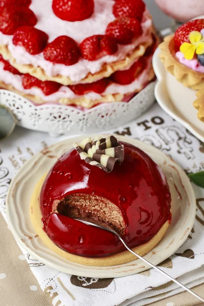Schokoladenkuchen mit roter Fruchtglasur. Festtisch, verschiedene Kuchen — Stockfoto