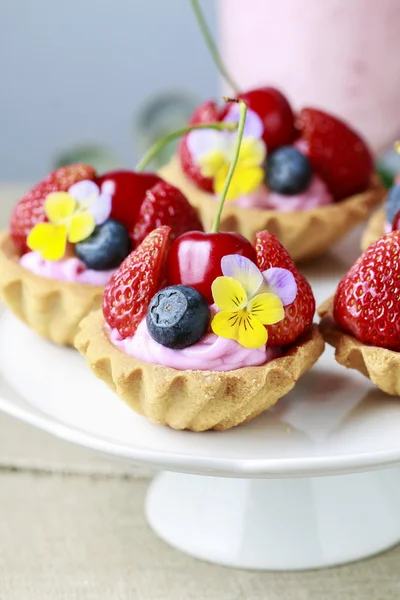 Košíčky s čerstvým ovocem a jedlé květy. — Stock fotografie