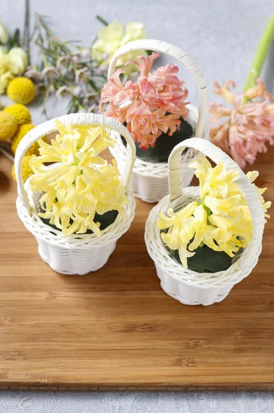 Wicker basket with spring flowers: hyacinth, carnations and waxf — Stock Photo, Image