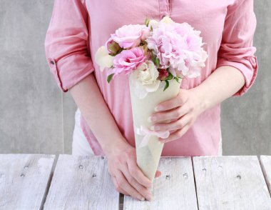İşteki çiçekçi: kadın, kağıttan kornet içinde kime çiçek düzenleyeceğini gösterir. Adım adım, öğretici.