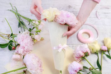 İşteki çiçekçi: kadın, kağıttan kornet içinde kime çiçek düzenleyeceğini gösterir. Adım adım, öğretici.