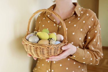 Paskalya yumurtalarıyla sepeti tutan bir kadın. Şenlik zamanı
