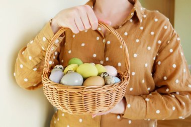 Paskalya yumurtalarıyla sepeti tutan bir kadın. Şenlik zamanı