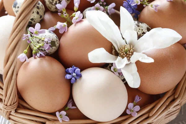 春の花で飾られた卵でいっぱいのウィッカーバスケット 祭りの時間 — ストック写真