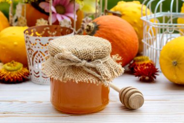 Masanın üzerinde cam kavanoz bal ve balkabağı var. Sağlıklı yemek.