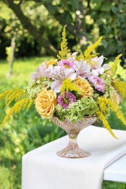 Çiçek aranjmanı gül, alstromerya ve eski bir kuş kafesinin içinde solidago çiçekleri. Adım adım, öğretici